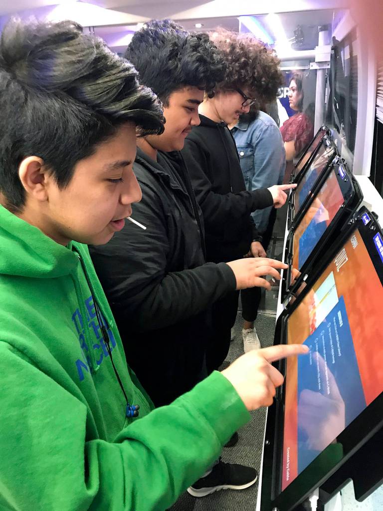 Students interact with large-screen tablets on the high-tech C-SPAN Bus during its stop at Kent-Meridian High School on Friday. MARK KLAAS, Kent Reporter