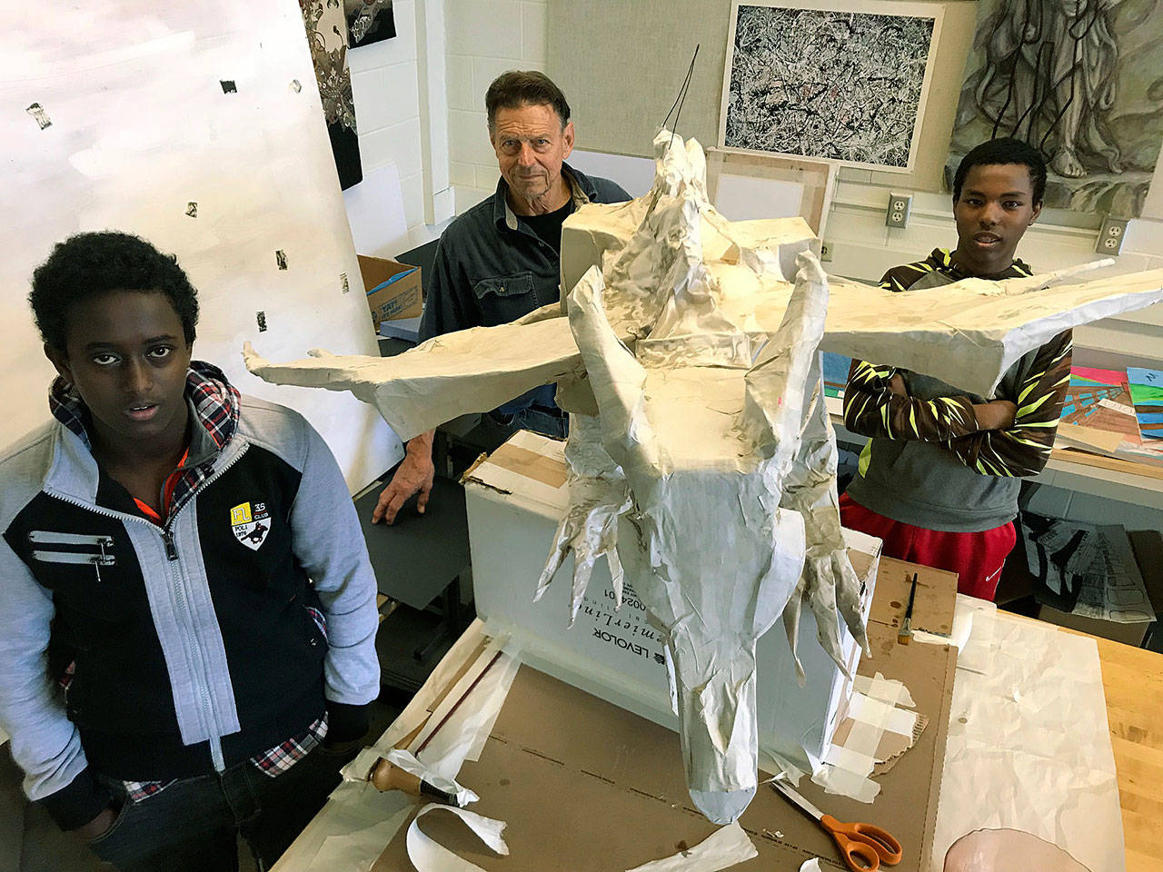 Kent-Meridian High School students Kaalid Arare, left, and Mohammed Shire worked with artist and volunteer Joe Lavely, middle, on the foundation for Maybelline the dragon, a public art project inspired by the popular series, Game of Thrones. The dragon will be a special guest at the Presidents Gala Business Leadership Excellence Awards presented by the Kent Chamber of Commerce and Republic Services on May 18 at the ShoWare Center. MARK KLAAS, Kent Reporter