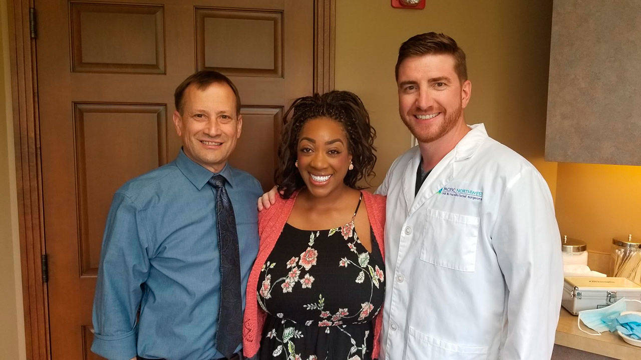 Doctors Cal Broadbent, left, and Ben Johnson, with India Coleman, after her final treatment in the Pacific Northwest Oral & Maxillofacial Surgeons Renton office. COURTESY PHOTO