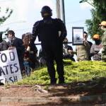 Riot-prepared police keep watch on an anti-fascist group, keeping protesters from engaging the Patriot Prayer, pro-life gathering at a demonstration Saturday outside the Planned Parenthood – Kent Valley Health Center. MARK KLAAS, Kent Reporter