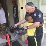 Kent Police Officer Jason Clift gets a big hug after delivering a new bicycle to a Kent boy. COURTESY PHOTO, Kent Police