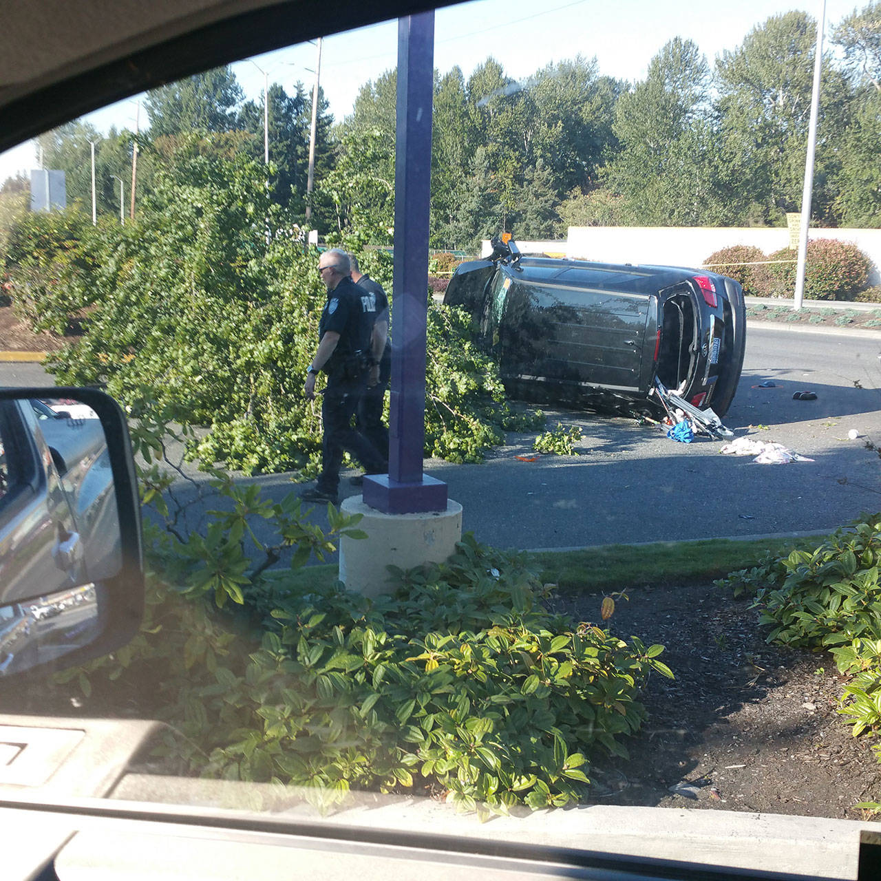 Kent Police investigate the scene of a crash that killed a pedestrian on Pacific Highway South. The driver of the vehicle who struck the pedestrian also hit a tree and another car before landing on its side. COURTESY PHOTO