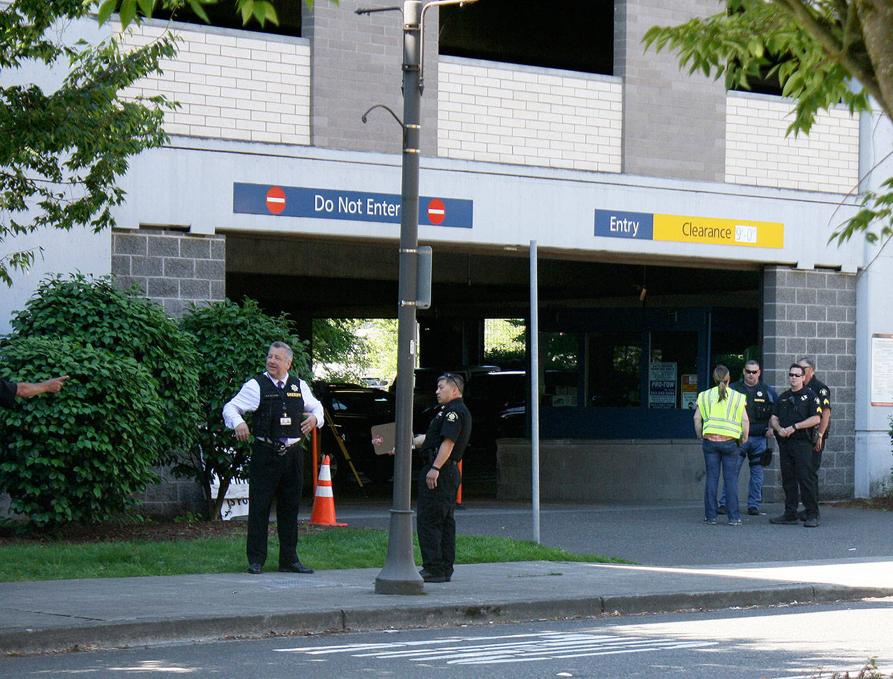 Police gather Thursday outside the Kent Station parking garage where a deputy fatally shot a man. STEVE HUNTER, Kent Reporter