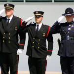 Officers salute the procession Tuesday for Kent Police Officer Diego Moreno outside the accesso ShoWare Center. STEVE HUNTER, Kent Reporter