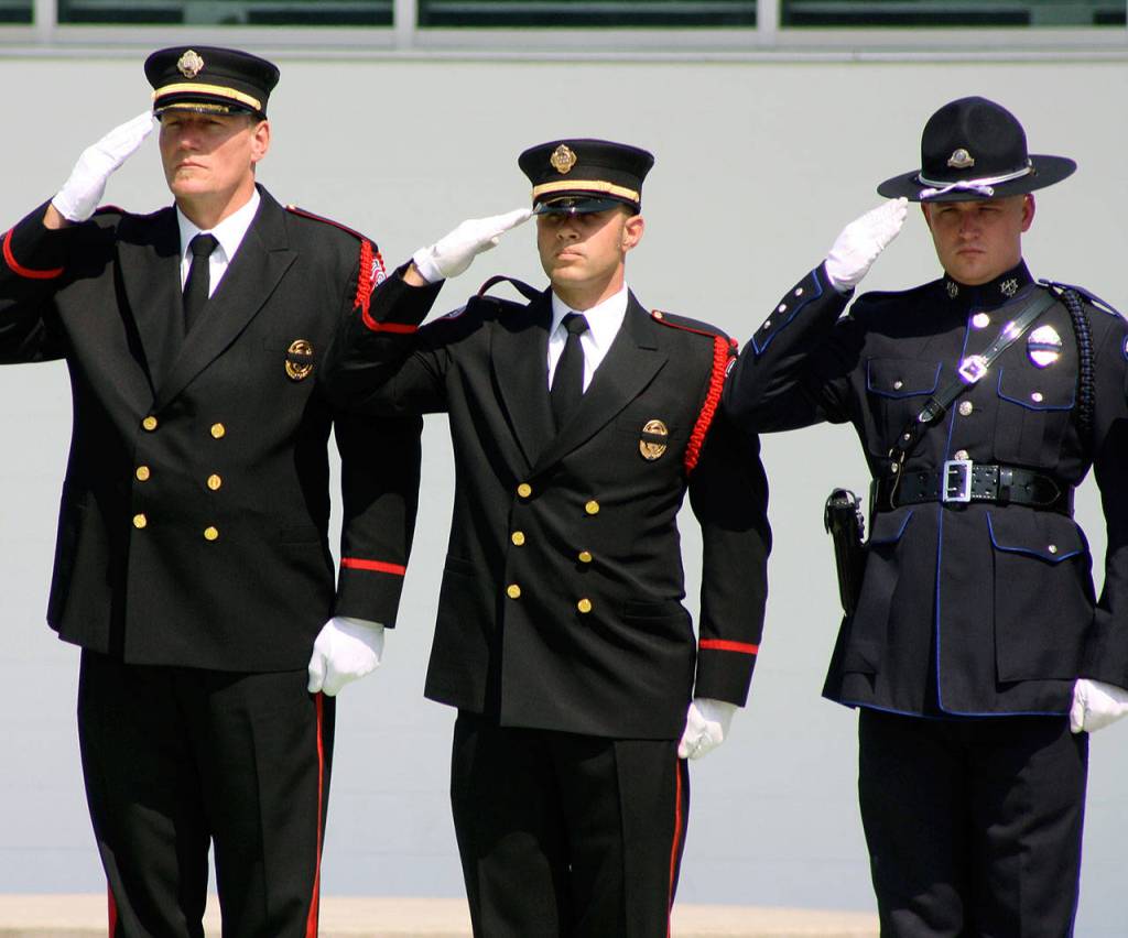 Officers salute the procession Tuesday for Kent Police Officer Diego Moreno outside the accesso ShoWare Center. STEVE HUNTER, Kent Reporter