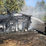 Firefighters mop up after dousing a detached garage fire in Kent on Sunday. No one was hurt in the fire. COURTESY PHOTO, Puget Sound RFA