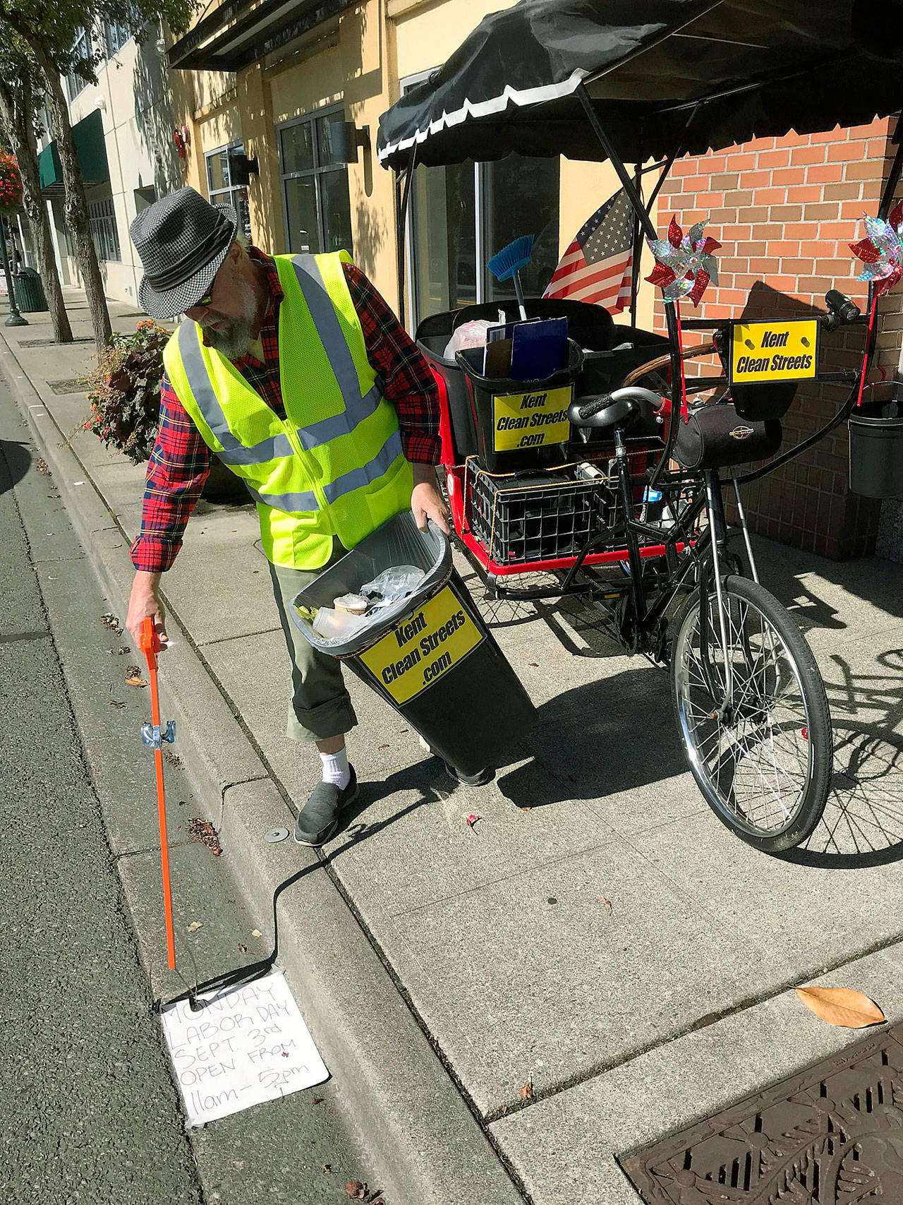Tom Burkley goes to work, picking up trash in downtown Kent on Tuesday. MARK KLAAS, Kent Reporter