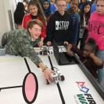 Serra McMurray, a Mattson seventh-grader, reaches for her teams robot after doing a run during the STEM event Tuesday. MARK KLAAS, Kent Reporter