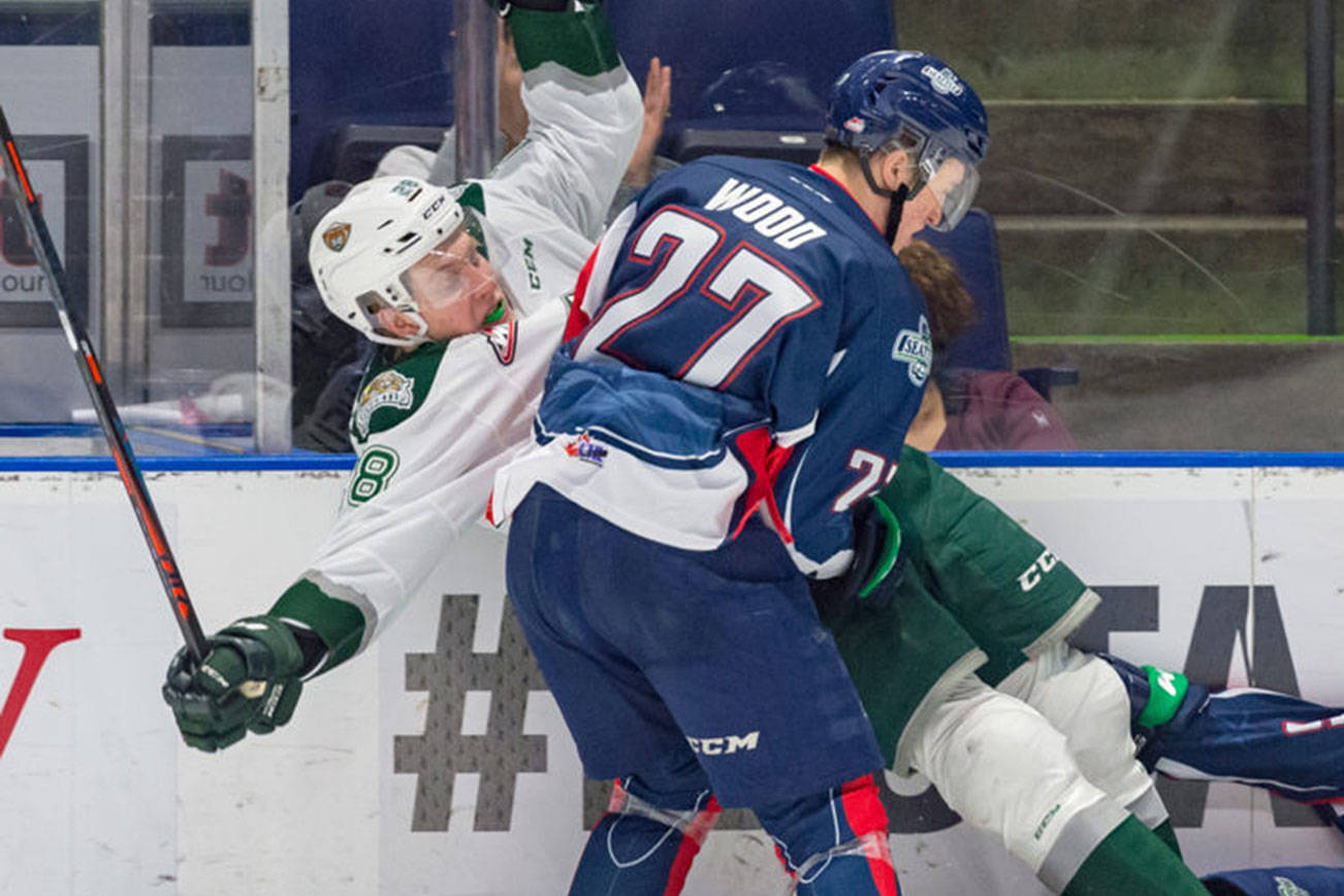 The Thunderbirds Wood checks the Silvertips Conrad Mitchell into the boards during WHL play Saturday night. COURTESY PHOTO, Brian Liesse, T-Birds