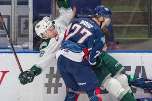 The Thunderbirds Wood checks the Silvertips Conrad Mitchell into the boards during WHL play Saturday night. COURTESY PHOTO, Brian Liesse, T-Birds