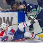 Thunderbirds defenseman Tyrel Bauer knocks the Chiefs Jack Finley to the ice during WHL play Tuesday night. COURTESY PHOTO, Brian Liesse, T-Birds