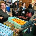Debbie Christian, executive director of the Auburn Food Bank, distributes fruit and other offerings to families during the United Way of King Countys Family Resource Exchange at Green River College last Saturday. MARK KLAAS, Auburn Reporter
