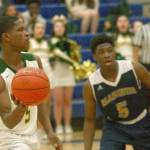 Kentridges Jeremy Banks looks to pass inside as Mariners Edwin Bouah defends during 4A regional boys basketball playoff action at Auburn Mountainview High School on Saturday night. Banks all-around game lifted the Chargers to a state-qualifying win. MARK KLAAS, Kent Reporter