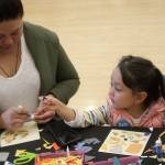 Di Cabere helps her daughter, Aci, 4, make a mosaic. MARK KLAAS, Kent Reporter