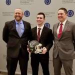 Hudson Potts receives his award with his coaches, Brett Thompson, left, and Kevin Hurt. COURTESY PHOTO