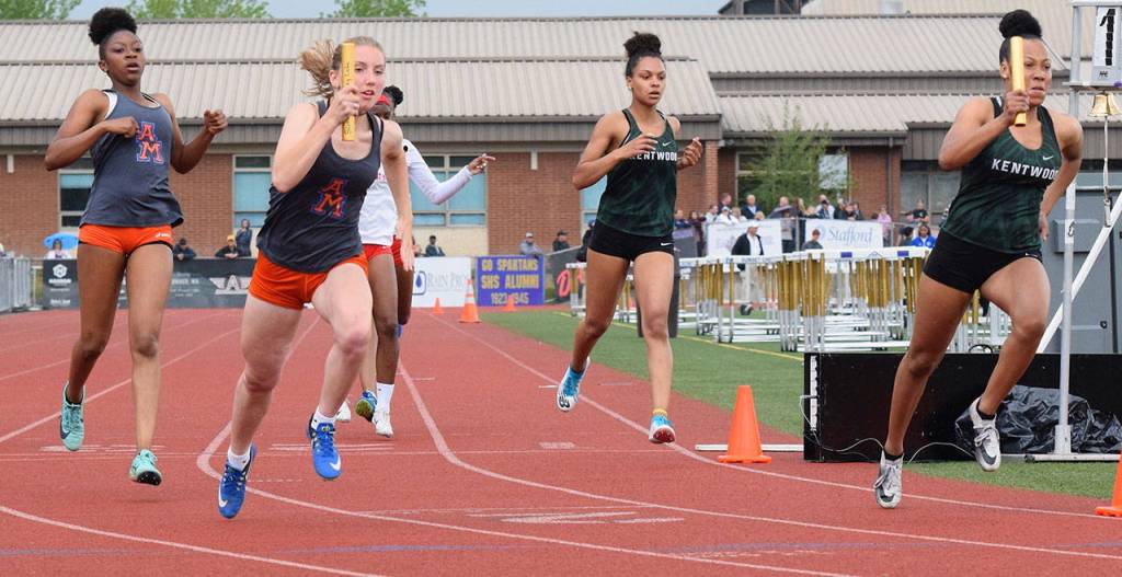 Kentwoods 800-meter relay captured the bi-district title in 1:41.50. Here, Faith Marshall passes the baton to MaKayla Williams, far right. RACHEL CIAMPI, Kent Reporter