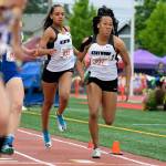 Faith Marshall passes the baton to Makayla Williams during Kentwoods 800-meter relay victory at the rain-soaked state track and field championships at Mount Tahoma High School in Tacoma last Saturday. RACHEL CIAMPI, Kent Reporter