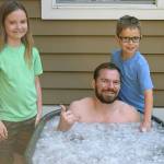 Justin Gielski, an American Ninja Warrior contestant, sits in an ice bath after a workout. With him are his two children, Sophie, 9, and Axel 8. COURTESY PHOTO