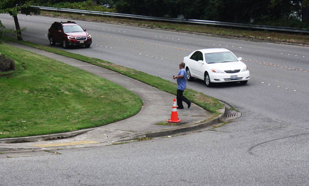 A man hustles to get across Reith Road at the intersection with Lake Fenwick Road South on a recent morning. STEVE HUNTER, Kent Reporter