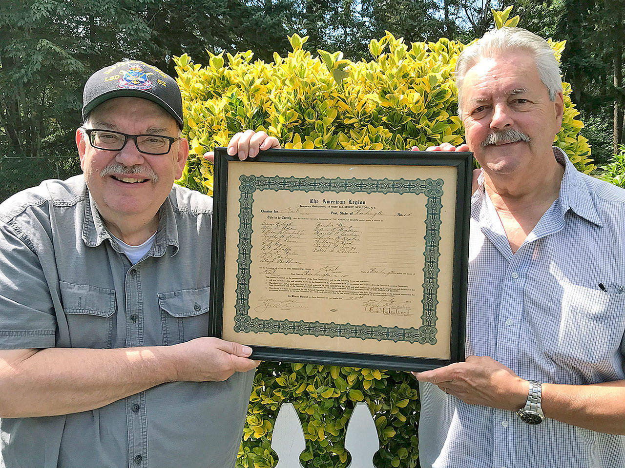 John Fredrickson, historian for Kents American Legion Post 15, left, and Post Commander Don Whittington, display the Posts original 1919 chartering document outside Kent Memorial Hall. MARK KLAAS, Kent Reporter