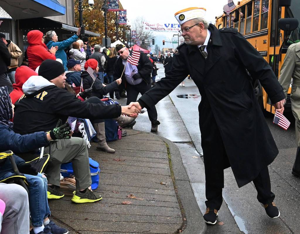 A veteran in the parade comes to shake hands with veteran Joe Lizama. RACHEL CIAMPI, Auburn Reporter
