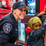 A Kent Police officer poses with a child at the Heroes & Helpers (shop with a cop) event. Dec. 7 at Target. COURTESY PHOTO, City of Kent
