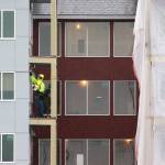 A man works on a balcony at the Cedar Pointe Apartments, a 255 apartment complex for seniors 55+, on Jan. 6, 2020, in Arlington, Washington. (Andy Bronson/The Herald)