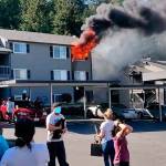 People flee and watch a fire Monday at the Apex West Hill Apartments. A bystander took the photo prior to firefighters arriving. COURTESY PHOTO, Puget Sound Fire