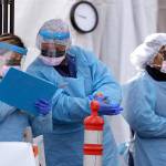 Medical personnel complete administrative work after testing a patient at a drive-through coronavirus testing station for University of Washington Medicine patients March 17 in Seattle. (AP Photo/Elaine Thompson)