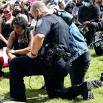Kent Police Chief Rafael Padilla invites the crowd to take a knee with him on the lawn of the Maleng Regional Justice Center on June 11. STEVE HUNTER, Kent Reporter