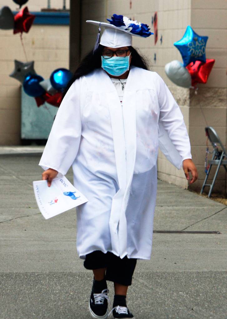 A student makes the graduation walk July 7 across the Kent-Meridian campus. STEVE HUNTER, Kent Reporter
