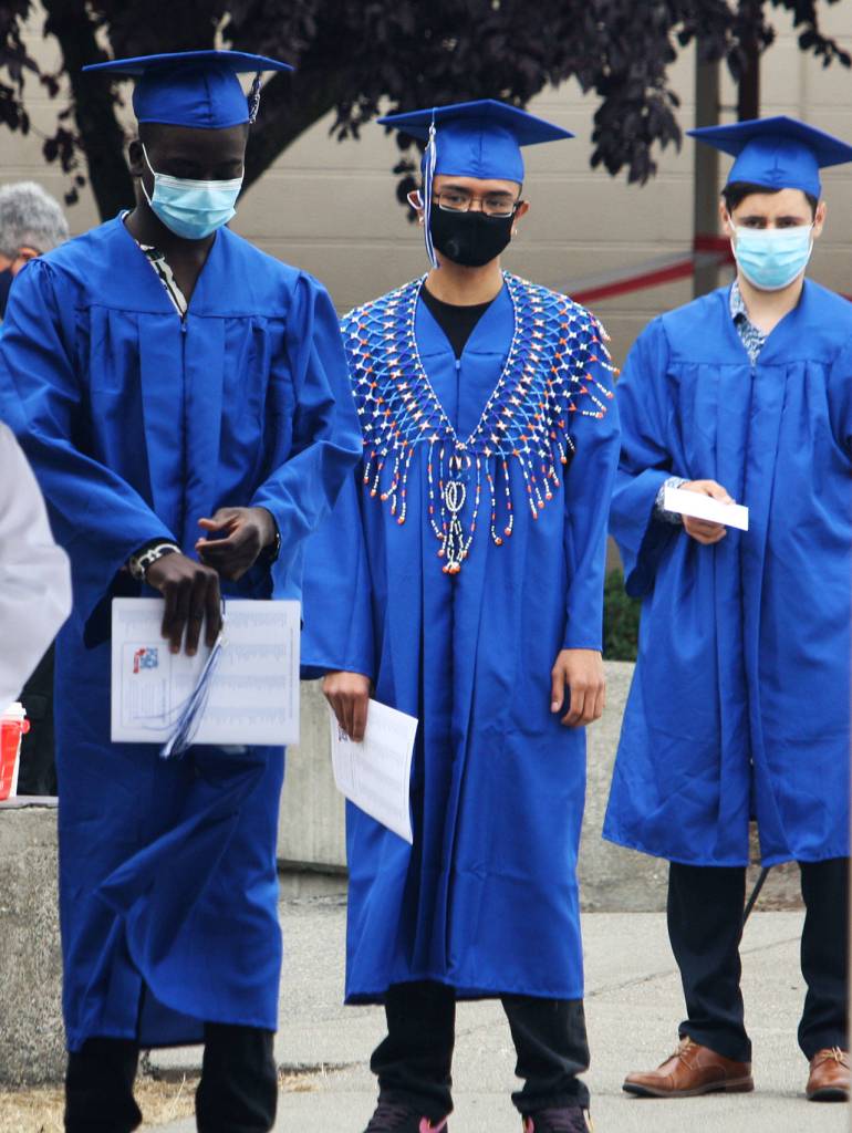 Three Kent-Meridian graduates line up to get ready to cross the stage for their official photo. STEVE HUNTER, Kent Reporter