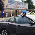 A Kent-Meridian graduate jumps back in his family vehicle after leaving the stage. STEVE HUNTER, Kent Reporter