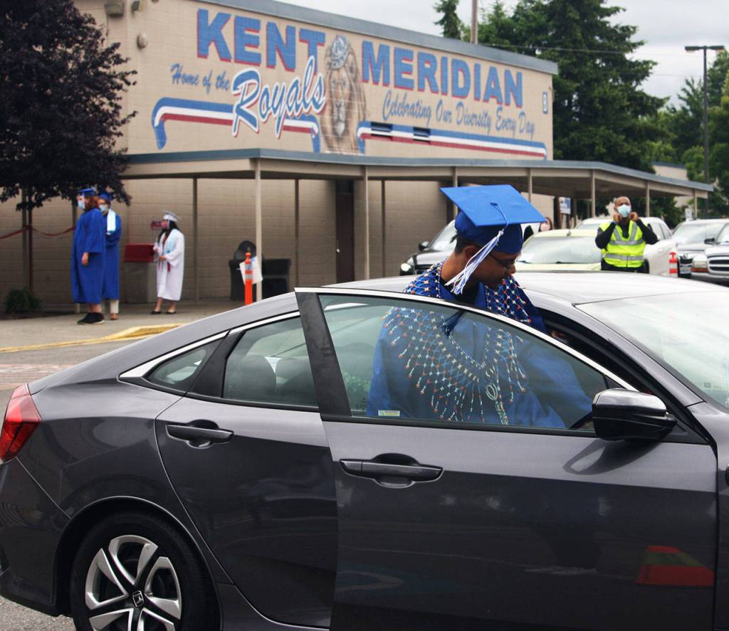 A Kent-Meridian graduate jumps back in his family vehicle after leaving the stage. STEVE HUNTER, Kent Reporter