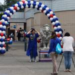 A graduate prepares to pose for a photo next to the Kent-Meridian lion statue. STEVE HUNTER, Kent Reporter