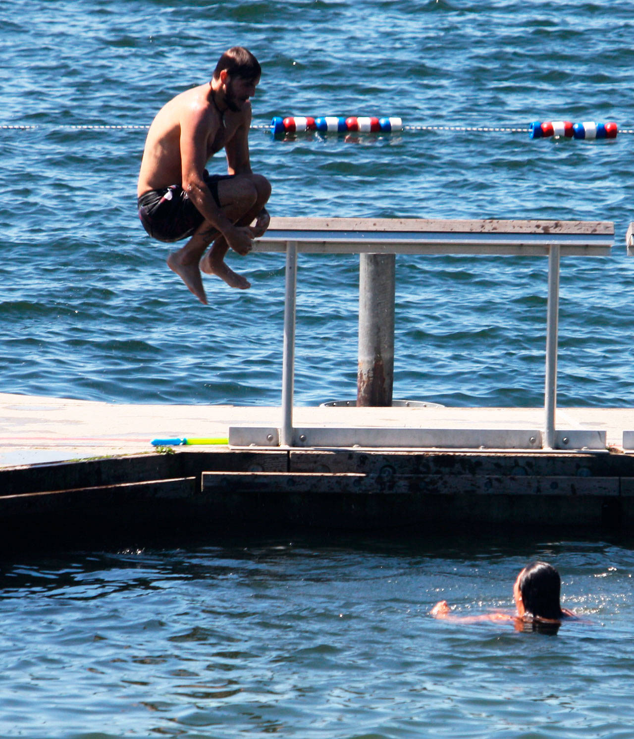 A swimmer jumps off the dock into Lake Meridian on Monday, July 13. STEVE HUNTER, Kent Reporter