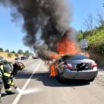 Firefighters attack a car fire Monday morning, July 27, along Interstate 5 northbound near the South 188th Street exit in SeaTac. COURTESY PHOTO, Tukwila Fire