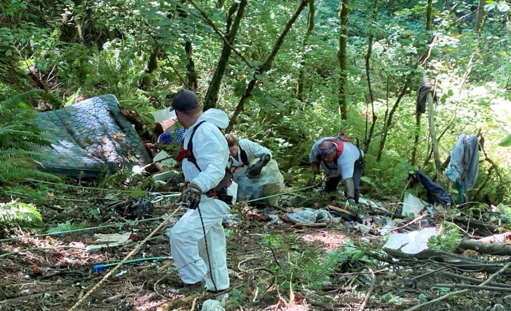 COURTESY PHOTO, City of Kent
Crews from Clean Harbors Environmental Services use pulleys and rope to gather trash left by homeless encampments along the steep slopes at Mill Creek Canyon.