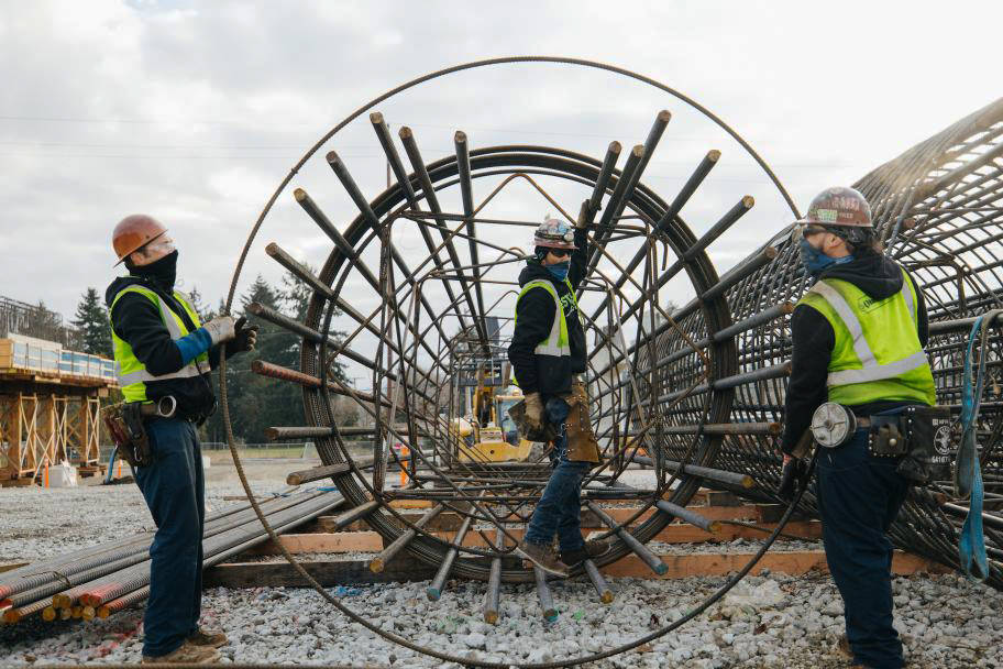 Ironworkers maneuver steel cages earlier this year to support columns at the future Kent/Des Moines light rail station. COURTESY PHOTO, Sound Transit