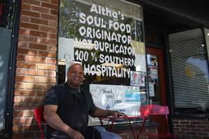 Owner Reginald Robinson sits in front of his deli (photo credit: Cameron Sheppard)