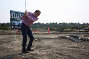 Renton Mayor Armondo Pavone takes ceremonial swing at the future site of Topgolf. Cameron Sheppard, Sound Publishing