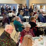 Attendees bow their heads in prayer prior to a Dec. 10 holiday luncheon at the Kent Senior Center presented by Puget Sound Fire. COURTESY PHOTO, Puget Sound Fire