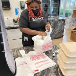 A Nanas Southern Kitchen employee bags up dinners Christmas Day for a free meal to people in need. COURTESY PHOTO, Nanas Southern Kitchen