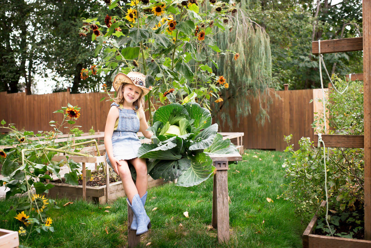 Maeryn Nau, of Kent, sits next to her winning cabbage that earned her $1,000 for the best cabbage in the state. COURTESY PHOTO,