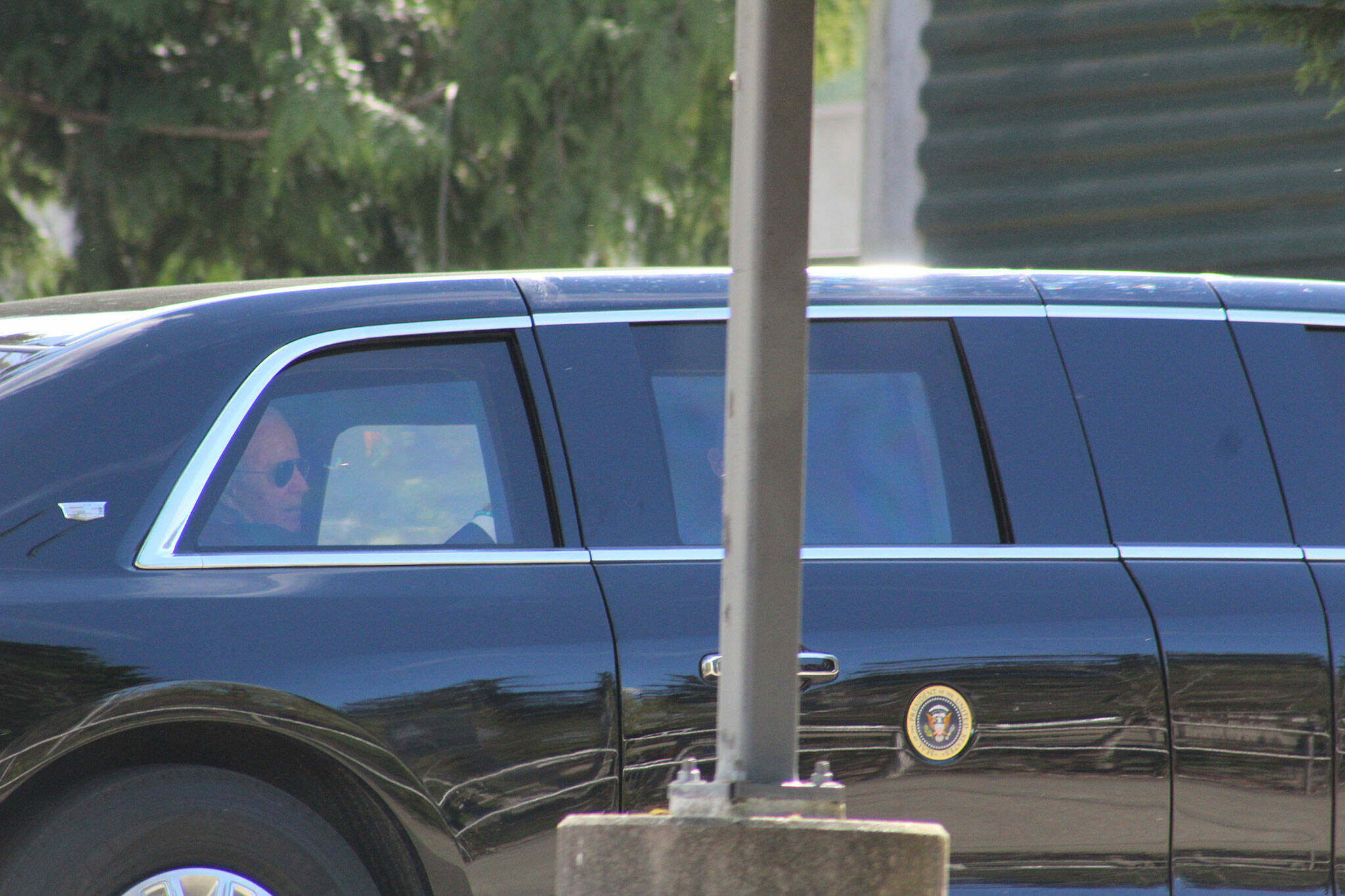 A man who appears to be President Joe Biden is seen in the back seat of a car in the presidents motorcade, departing the Green River College after the presidents speech. Photo by Alex Bruell/Sound Publishing