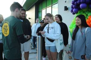 Claire Hansen, center, is handed card No. 1 on Aug. 11 outside of Amazon Fresh in Federal Way. Olivia Sullivan/the Mirror