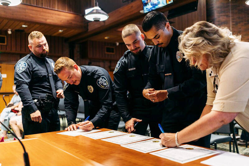 Kent Mayor Dana Ralph and four Kent Police officers sign the proper documents in August after the mayor swore them in. COURTESY PHOTO, Kent Police