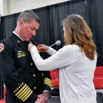 Megan Carson, the wife of new Puget Sound Fire Chief Brian Carson, pins his badge on after he was sworn in as chief Feb. 16. COURTESY PHOTO, Puget Sound Fire