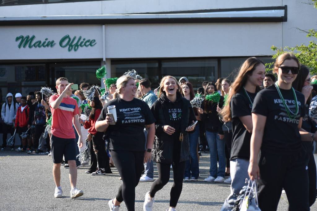 Coaches smiling and cheering their girls on the bus. Ben Ray / The Reporter
