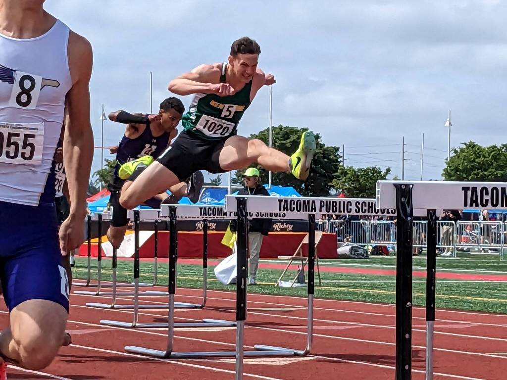 Senior Alex Conner leaps over a hurdle on his way to first place. Ben Ray / The Reporter